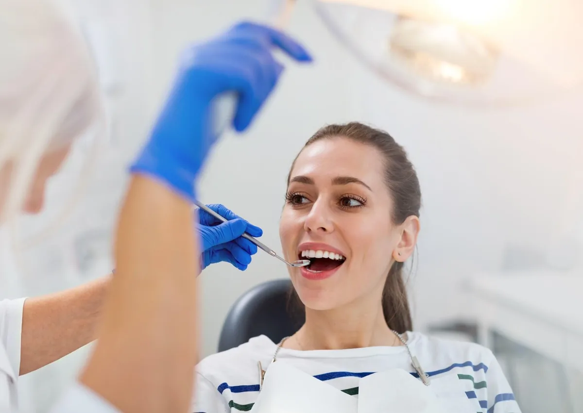 Dentist examining a patient’s teeth to assess tooth count and overall oral health.