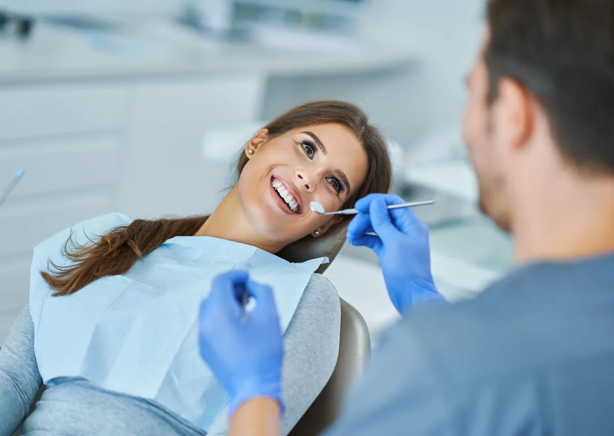 Patient attending a dental follow-up while discussing recovery and what to eat after dental implant surgery.