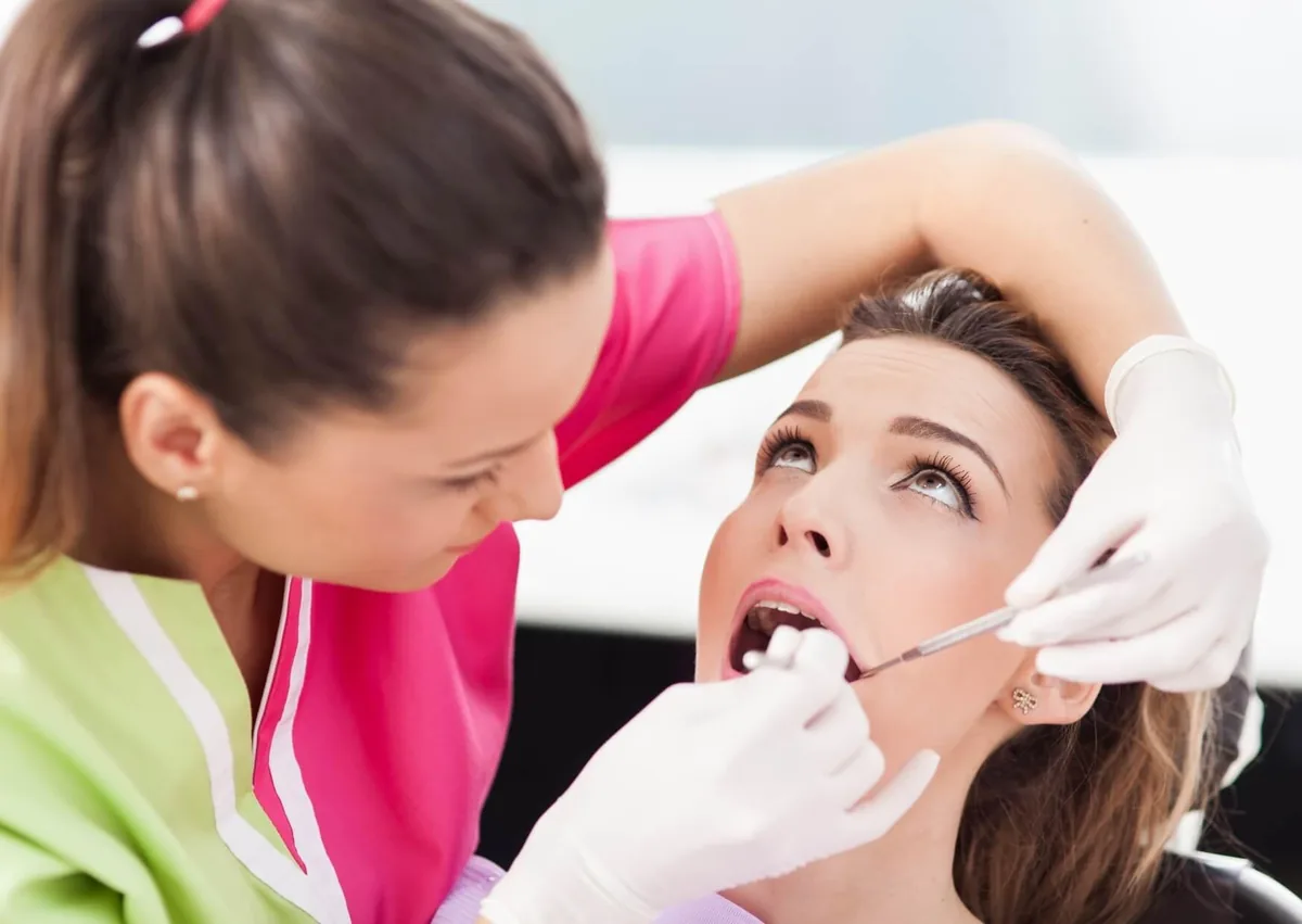 Dentist examining a patient for oral health concerns related to persistent dry mouth.