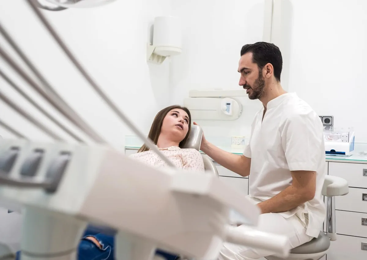 Dentist discussing why to avoid dairy after dental implant surgery during a patient consultation.